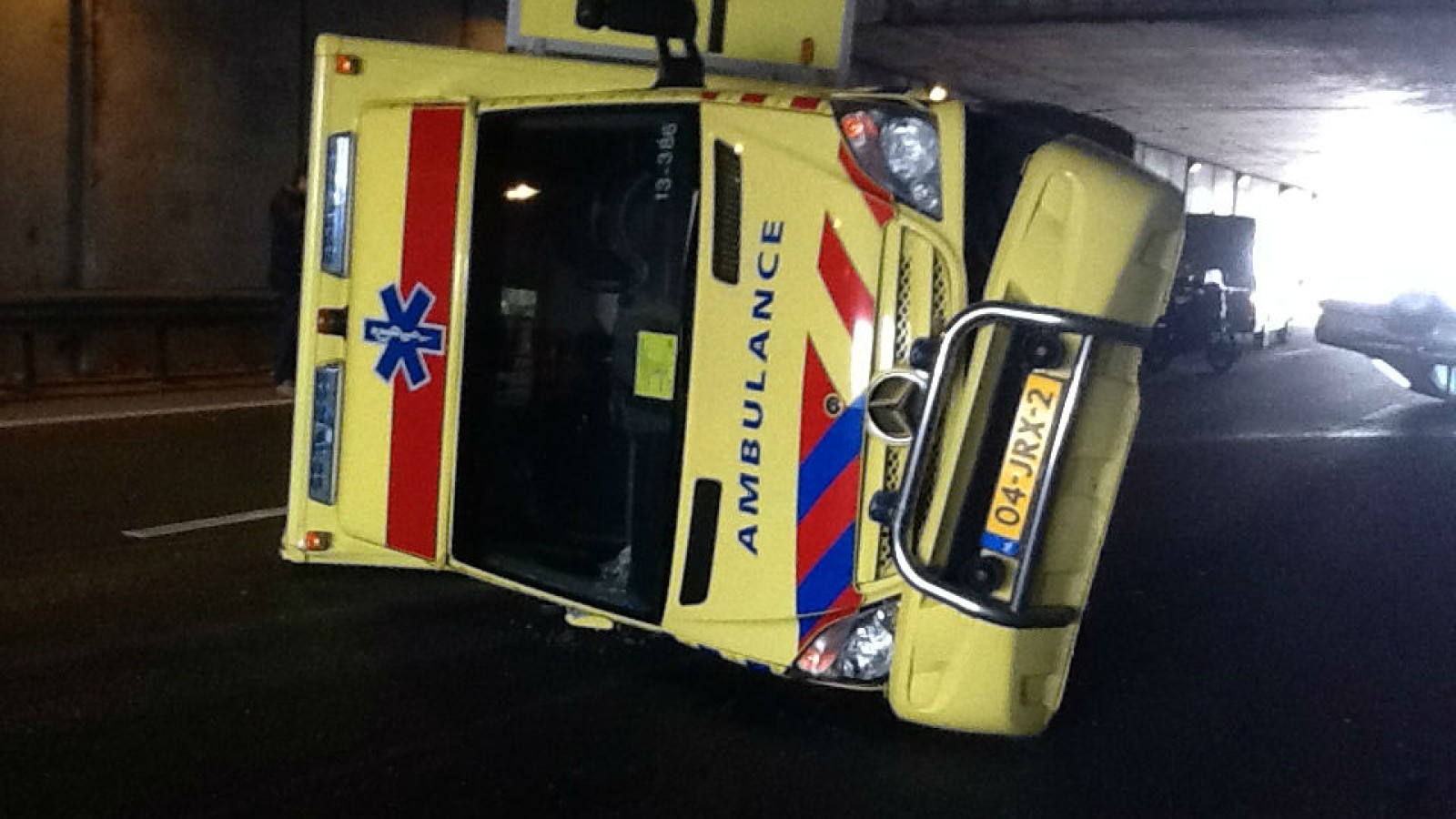 Ambulance op zijn kant na botsing op A10