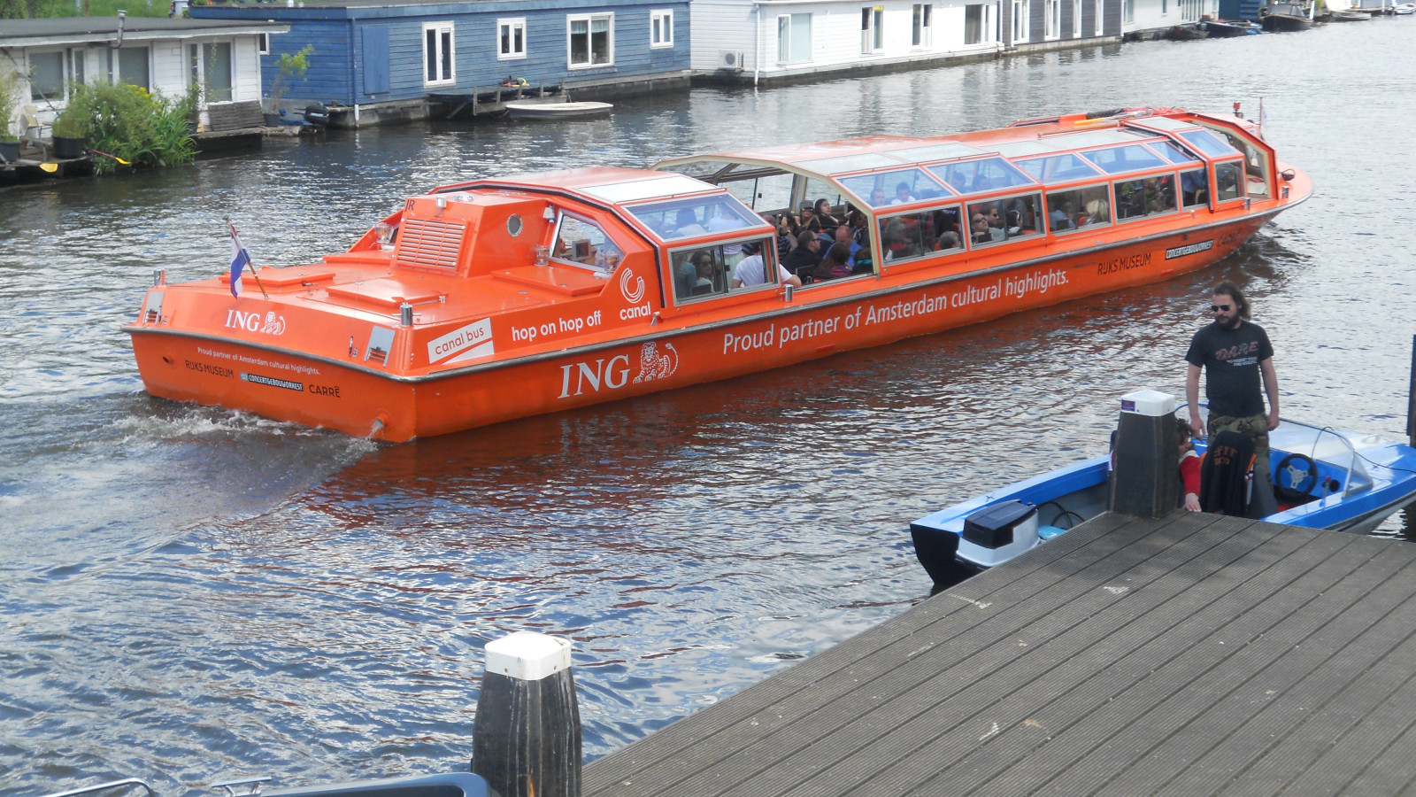 Tijdens deze zonnige dag konden Toeristen mooi gelegenheid maken van de Hop-On-Hop-Off Canalboat om een Rondvaart te maken en te genieten van het mooie Weer. Deze Rondvaartboot vaart door de grachten van Amsterdam en stopt aan diverse aanllegsteigers bij 