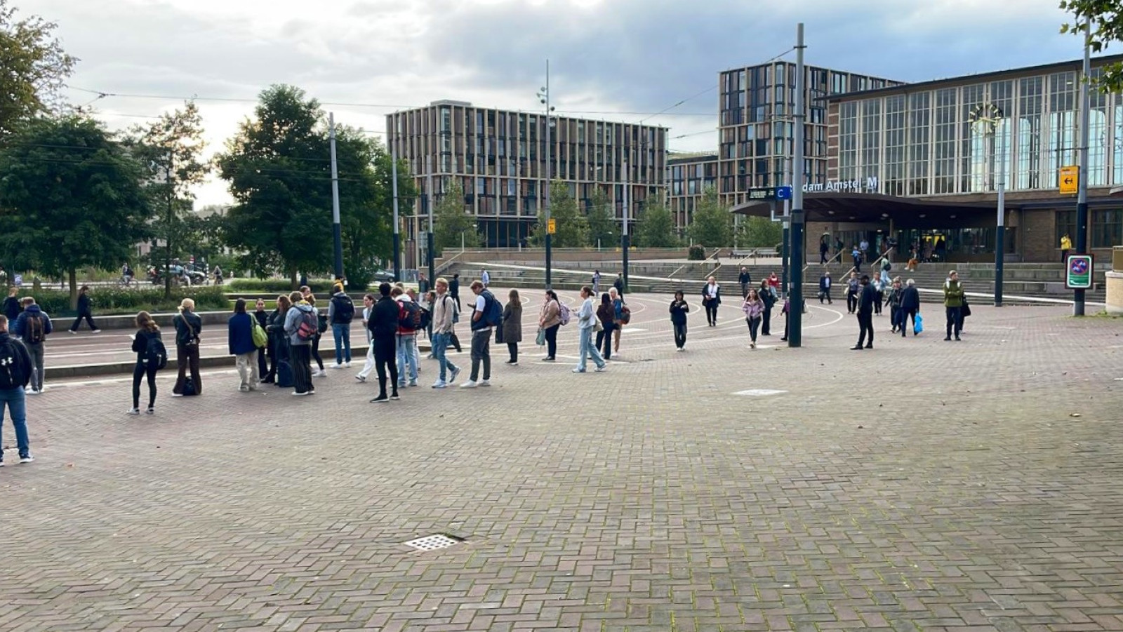 Reizigers wachten op trams bij Amstelstation