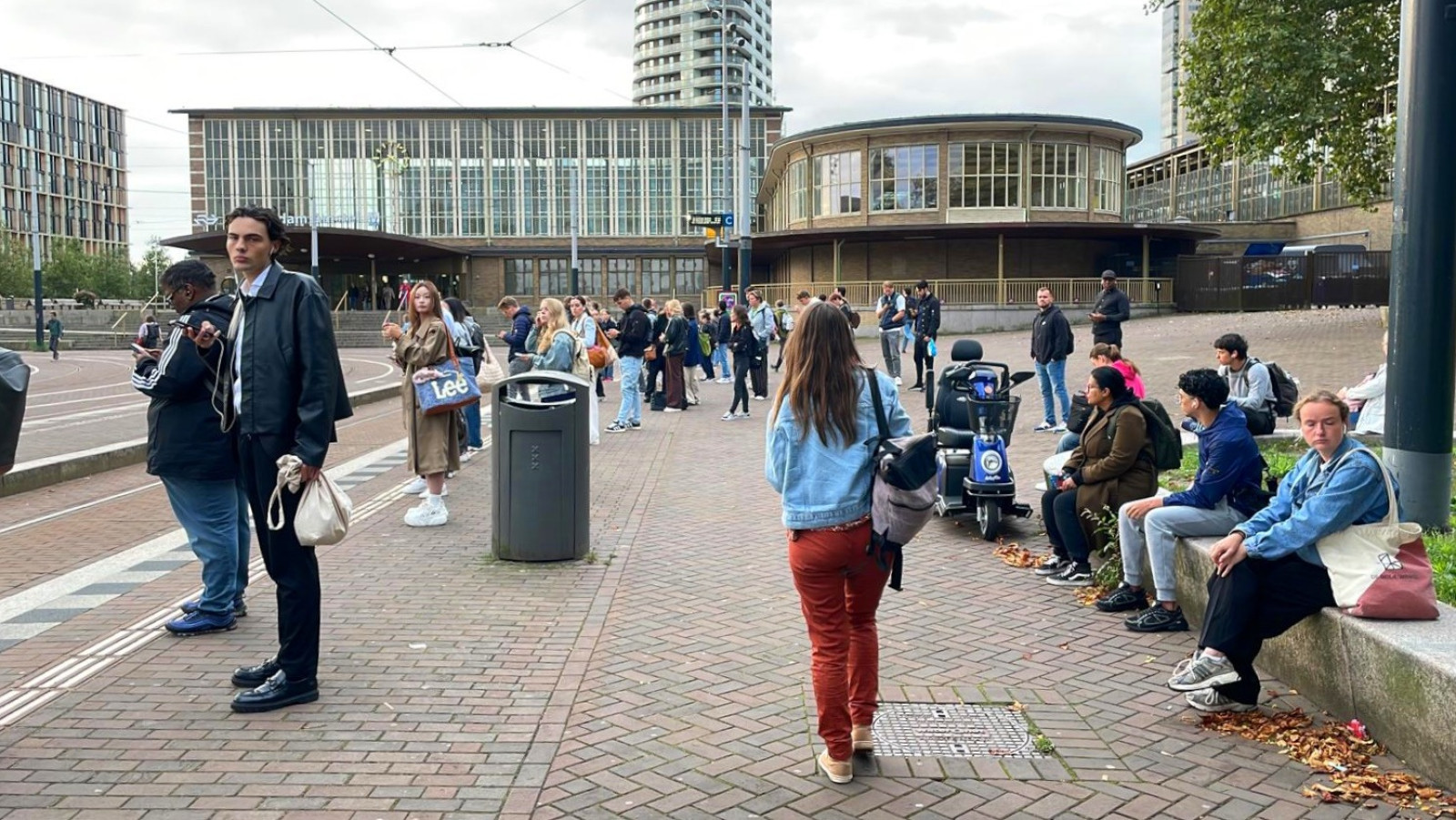 Reizigers wachten op trams bij Amstelstation