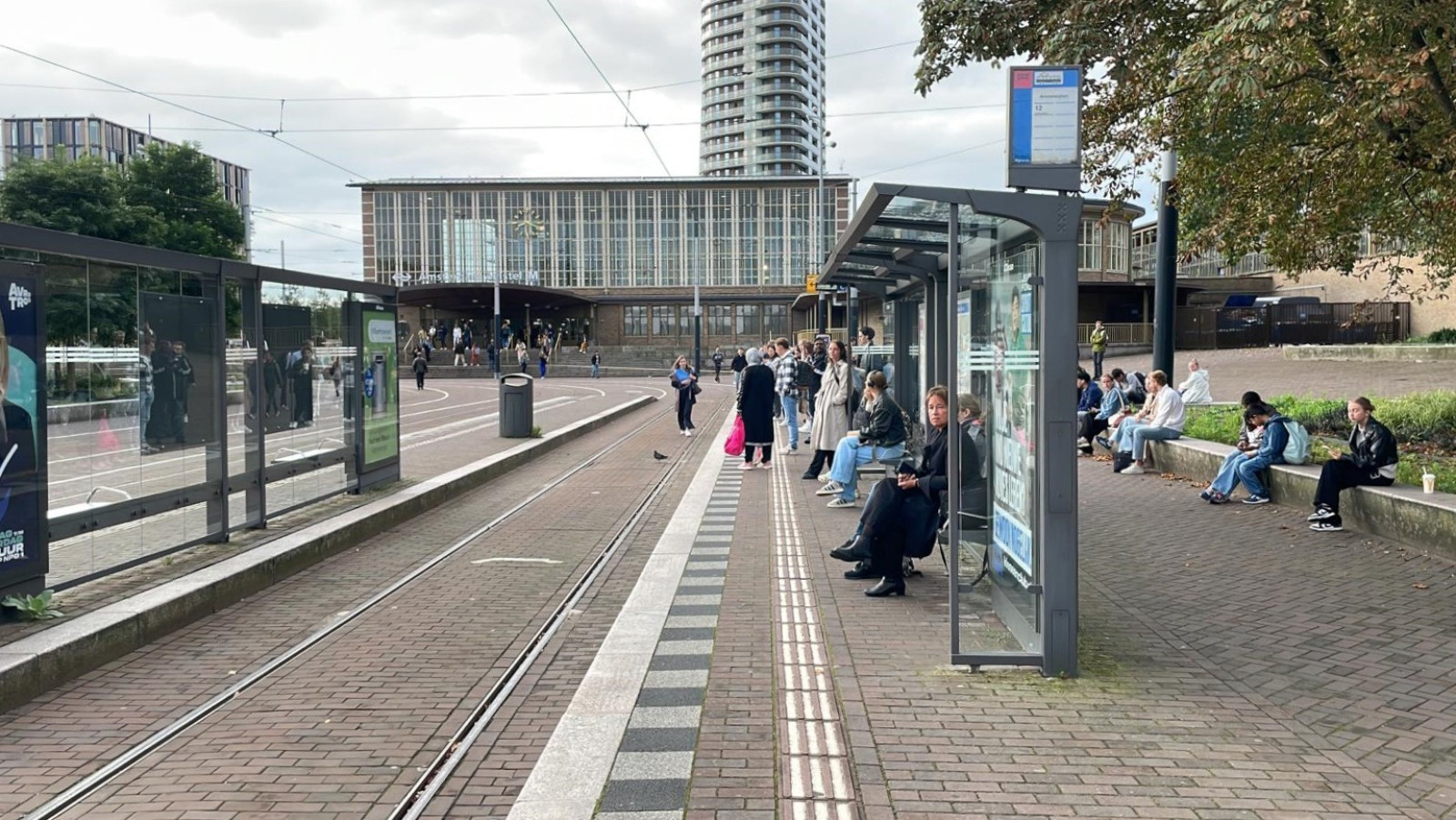 Reizigers wachten op trams bij Amstelstation