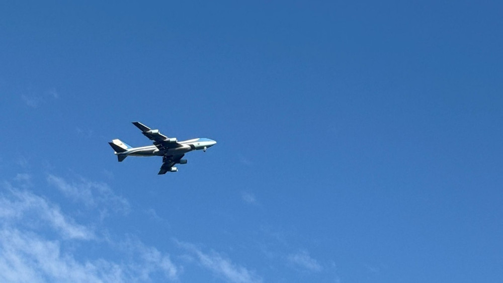 President Trump vliegt in Air Force One over de stad
