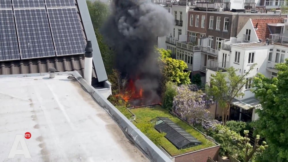 Brand in tuin van winkel Willemsparkweg, rookwolk door de hele stad te zien