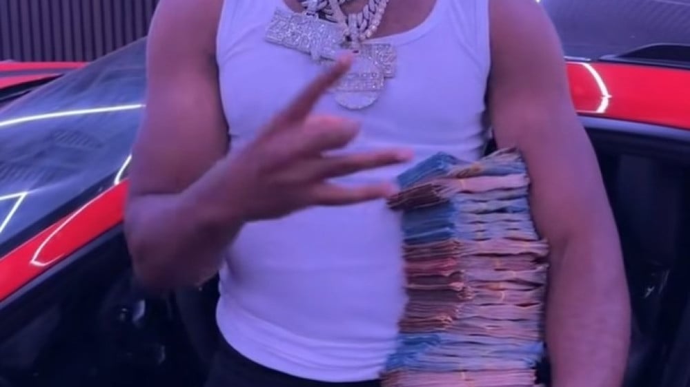 Rapper JoeyAK laat met stapel geld zien dat hij - onder voorwaarden - uit de gevangenis is
