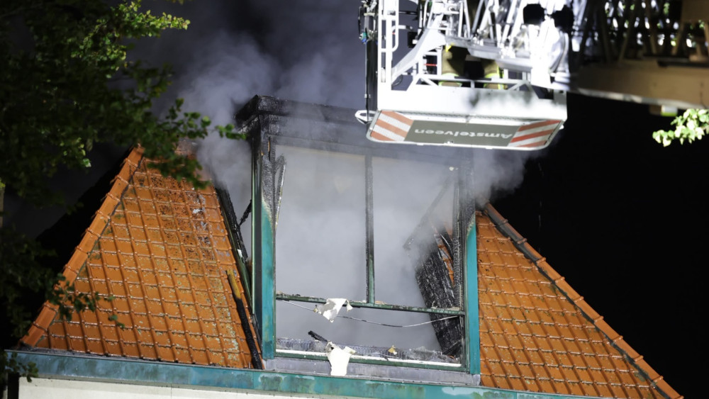Grote brand in woning langs Amsteldijk, vlammen slaan uit het dak