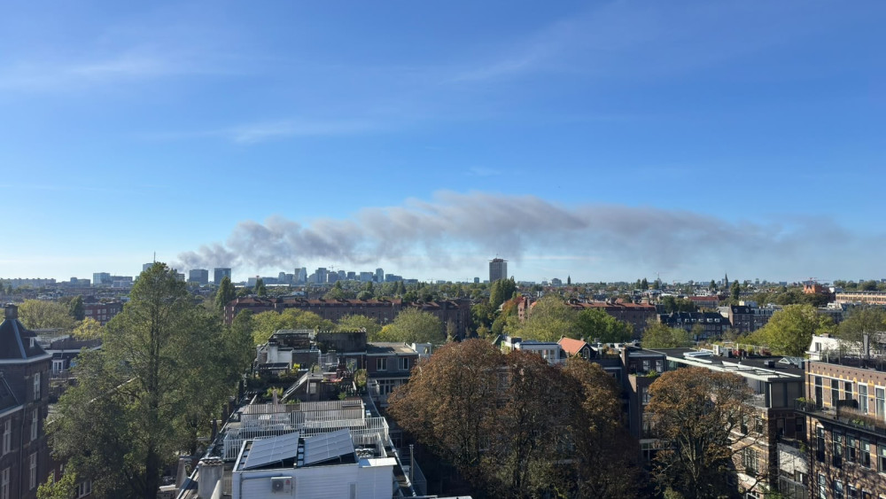 Grote rookwolk te zien in de stad door brand bij loods Aalsmeer